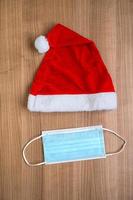 Santa Claus hat and face mask creative minimal concept flat lay of corona Christmas photo