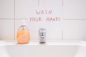 wash your hands handwritten notice above bathroom sink photo