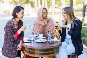 riendo diversas mujeres en café al aire libre foto