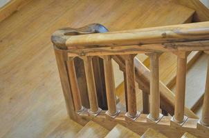 Ancient wooden stairway with wooden steps and handrail photo