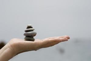 Gravel pile in woman's hands with sea background photo