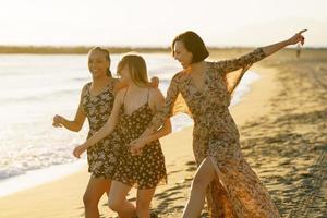 riendo diversas mujeres disfrutando de la puesta de sol en la playa foto