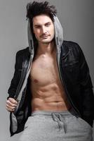 Athletic man wearing hoodie jacket. Studio shot photo