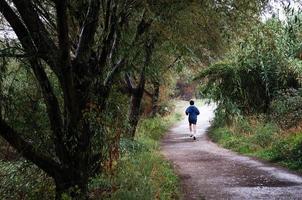 Woman runner running in autumn forest photo