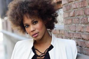 Young black woman with afro hairstyle standing in urban background photo