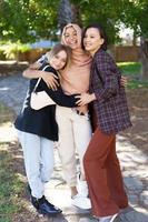 Delighted young diverse ladies embracing and smiling in park photo