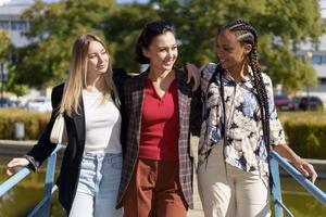 Positive diverse women on footbridge in city photo