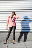 Black woman, model of fashion, standing on urban wall photo