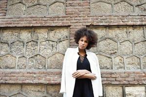 Young black woman with afro hairstyle standing in urban background photo