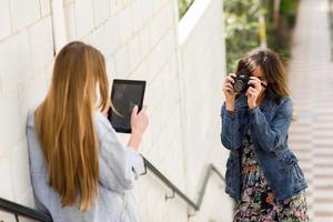 Two young tourist women taking photographs outdoors photo