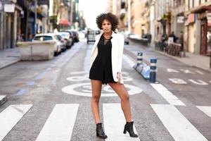 Young black woman with afro hairstyle standing in urban background photo