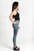Young woman wearing black tank top and blue jeans photo
