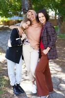 Delighted young diverse ladies embracing and smiling in park photo