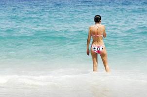 Sexy back of a beautiful woman in bikini on sea background.