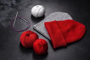 Red warm knitted women's hat on a concrete background photo