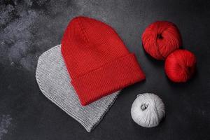 Red warm knitted women's hat on a concrete background photo