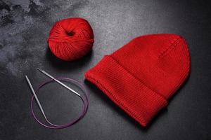 Red warm knitted women's hat on a concrete background photo