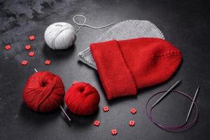 Red warm knitted women's hat on a concrete background photo