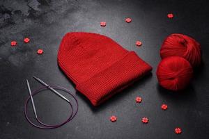 Red warm knitted women's hat on a concrete background photo