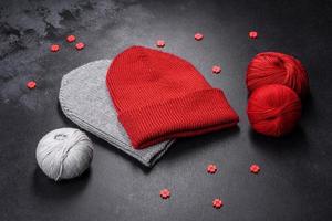 Red warm knitted women's hat on a concrete background photo