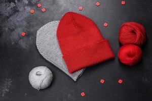 Red warm knitted women's hat on a concrete background photo