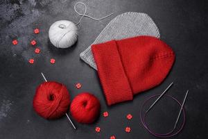 Red warm knitted women's hat on a concrete background photo