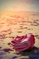 toalla de playa en la arena con gafas de sol de estilo antiguo. imagen vertical foto