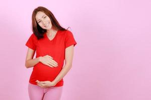 Half length portrait of beautiful caucasian young pregnant model caressing tender touch her belly. Pregnant happy new mother posing indoor put hand soft touching on tummy. Love and family concept photo