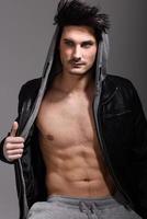 Athletic man wearing hoodie jacket. Studio shot photo