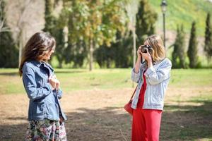 Two young tourist women taking photographs outdoors photo