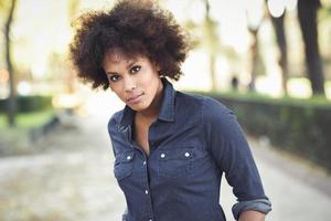 Young black woman with afro hairstyle standing in urban background photo