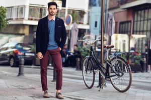 Man wearing british elegant suit in the street near an old bycicle photo