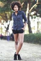 Young black woman with afro hairstyle standing in urban background photo