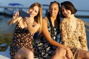 mujeres encantadas tomando selfie en el muelle