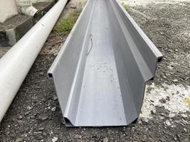 Close up of a PVC roof gutter on the ground, ready to be fix photo