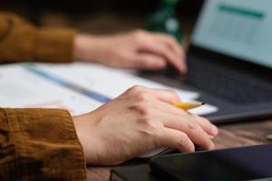 cierre la mano con el mouse y escriba en el teclado de la computadora portátil cuando trabaje en casa foto