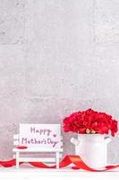 May mothers day handmade giftbox wishes photography - Beautiful blooming carnations with red ribbon box isolated on fair-faced gray background desk, close up, copy space, mock up photo