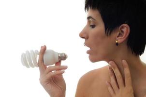 Woman holding bulb over white background photo