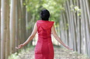 mujer vestida de rojo, meditando en el bosque foto