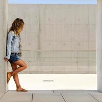 Young blonde woman against urban wall photo