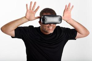 Man looking in VR glasses and gesturing with his hands. photo