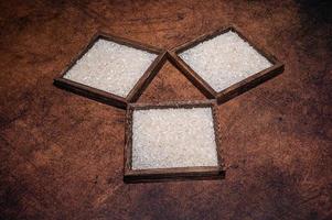 Some square containers of white rice in the dark background photo