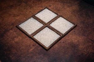 Some square containers of white rice in the dark background photo