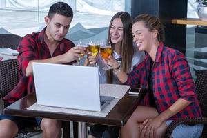 amigos tocando cerveza en la computadora portátil foto