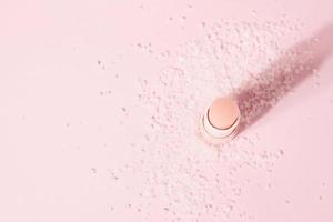 Exfoliante de bálsamo de sal de labios con sal sobre fondo rosa, espacio de copia