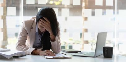 la mujer de negocios se estresa mientras tiene un problema en el trabajo en la oficina foto