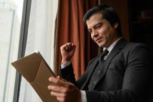 A young businessman monitors and keeps track of tasks in his office photo