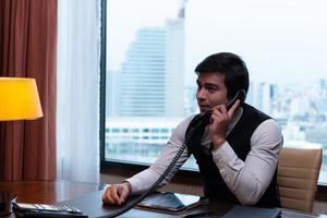 A young businessman monitors and keeps track of tasks in his office photo