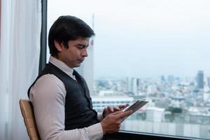 A young businessman monitors and keeps track of tasks in his office photo
