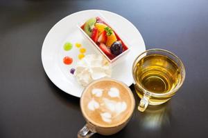 strawberry cream and a cup of tea and cofee on a wooden background, selective focus photo